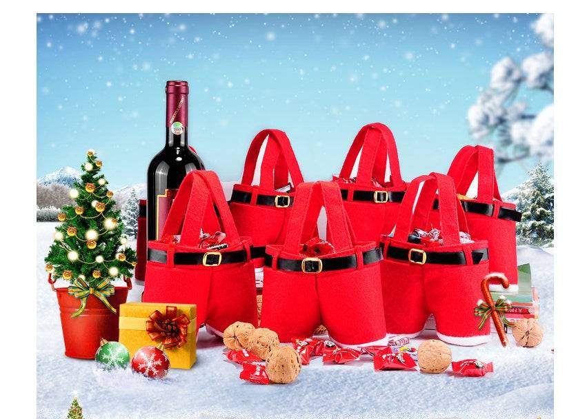 Christmas hot sale red velvet Christmas candy bags with black belt design next to holiday decorations and wine bottle