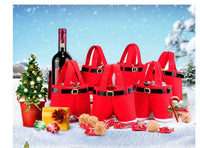 Christmas hot sale red velvet Christmas candy bags with black belt design next to holiday decorations and wine bottle