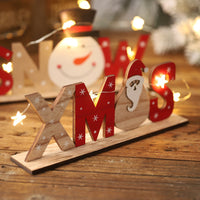 Set of Christmas wooden ornaments with festive letters and shapes including Santa, snowman, and snowflake designs.