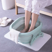 Foldable footbath massage bucket in green plastic with massage balls and towel on the side