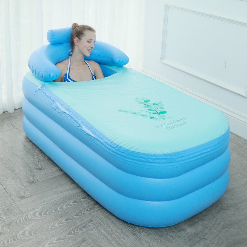 Woman relaxing in blue folding inflatable bathtub with pillow in indoor setting