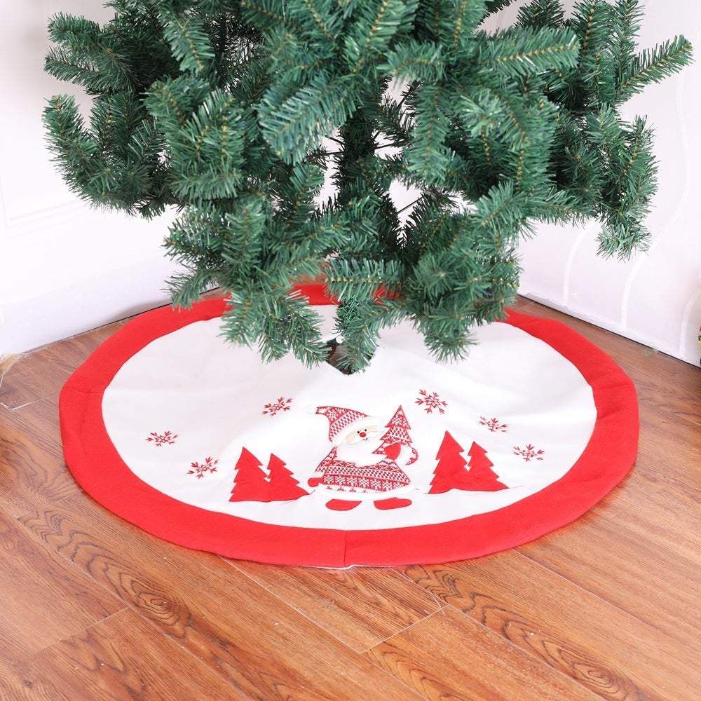Red and white Christmas tree skirt with gnome and tree design under a Christmas tree