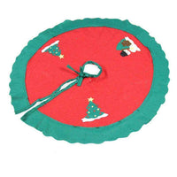 Red and green Christmas tree skirt with festive holiday decorations and tie string closure