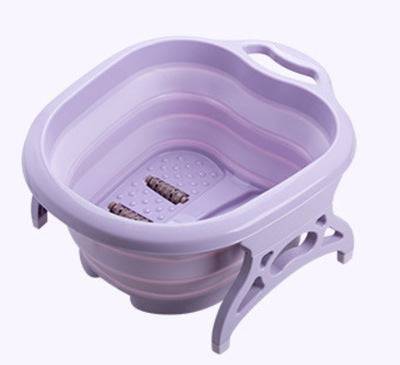 Foldable footbath massage bucket in purple plastic with built-in massage rollers and collapsible design for easy storage