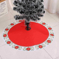Red Christmas tree skirt with poinsettia border under artificial tree, soft fabric material, available in multiple sizes