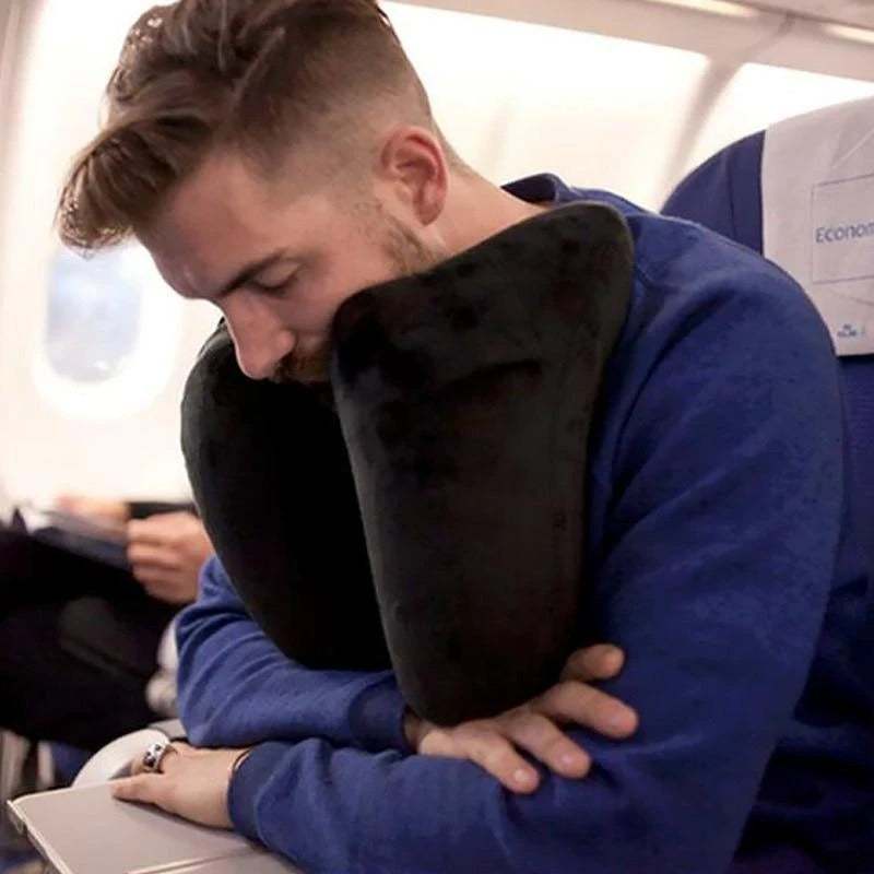 Man using black neck pillow travel pillow on airplane seat for comfort and support