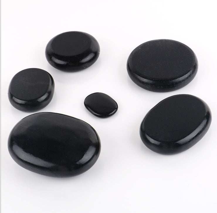 Black natural volcanic spa energy stones in various sizes for massage therapy