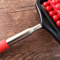 Telescopic plastic massage roller with red handle and stainless steel extension on wooden surface