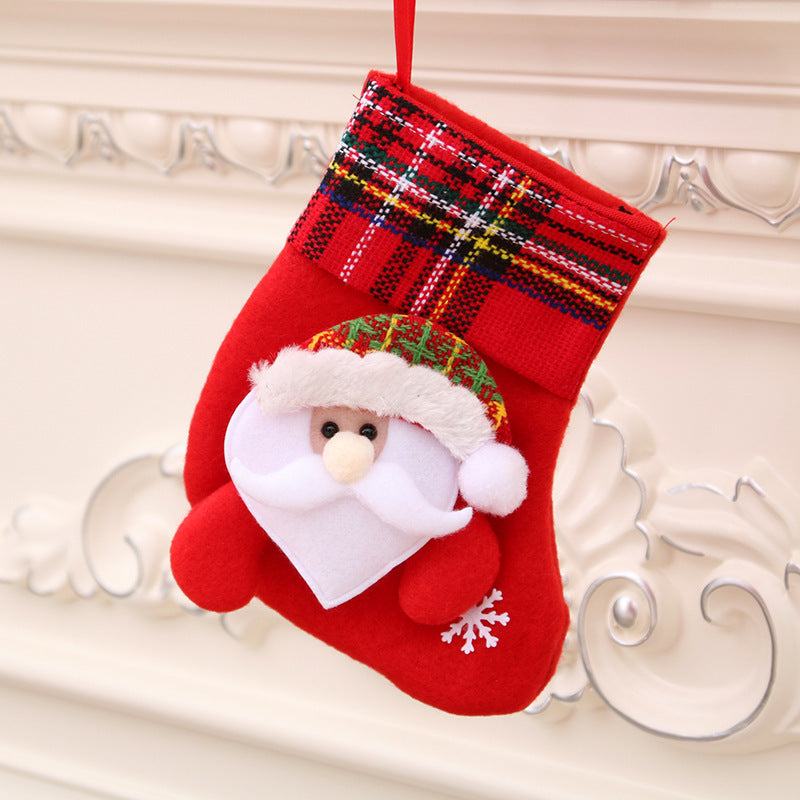 Red Christmas stocking with Santa Claus face and plaid cuff hanging on mantelpiece Christmas decorations