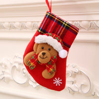 Red Christmas stocking with teddy bear decoration and plaid cuff hanging on wall Christmas decorations