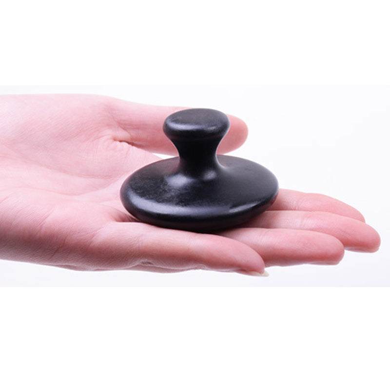 Black Bianstone mushroom head massage tool held in hand for facial and body relaxation