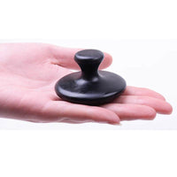 Black Bianstone mushroom head massage tool held in hand for facial and body relaxation