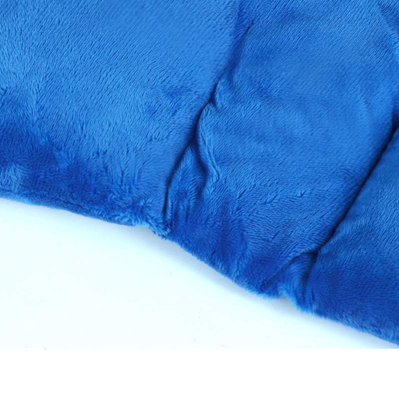 Man using blue flaxseed gravity neck shoulder pad for pain relief while working on laptop