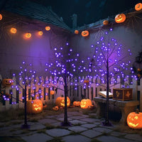 Set of three black Halloween spooky trees with purple LED lights in 4FT, 5FT, and 6FT sizes, decorated outdoors with glowing jack-o'-lanterns and pumpkin string lights.