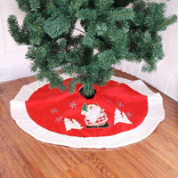 Christmas tree skirt with Santa Claus design in red and white under Christmas tree on wooden floor