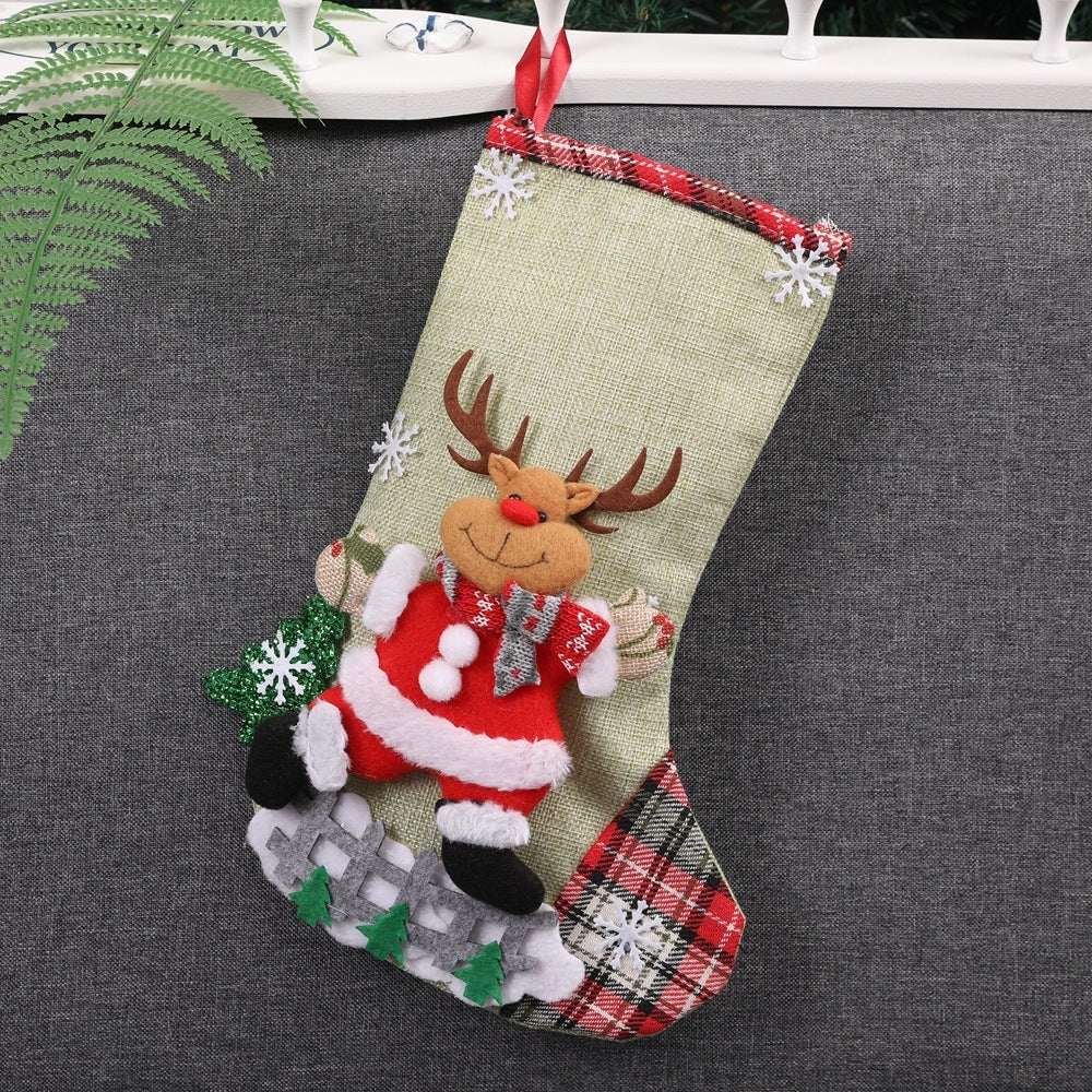 Christmas decoration fabric stocking with Santa Claus reindeer and festive embellishments hanging on a gray surface