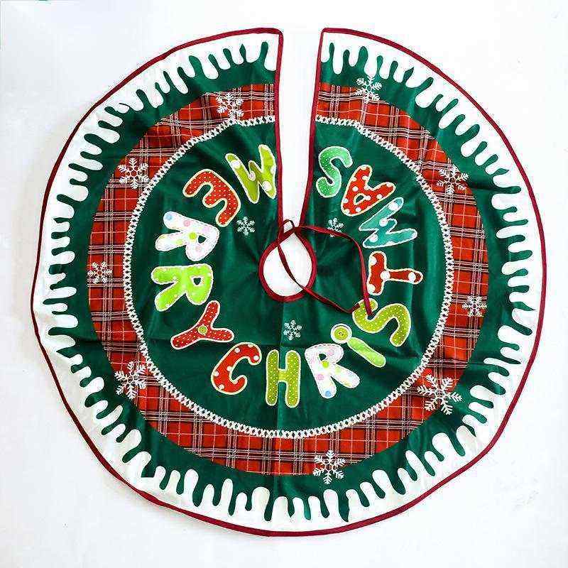 Green and red plaid Christmas tree skirt with "Merry Christmas" text and snowflake decorations