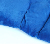 Man using blue flaxseed gravity neck shoulder pad for pain relief while working on laptop