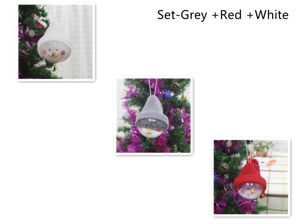 Set of three Christmas decorations featuring creative snowman plastic ball pendants with grey, red, and white knitted hats hanging on a Christmas tree.