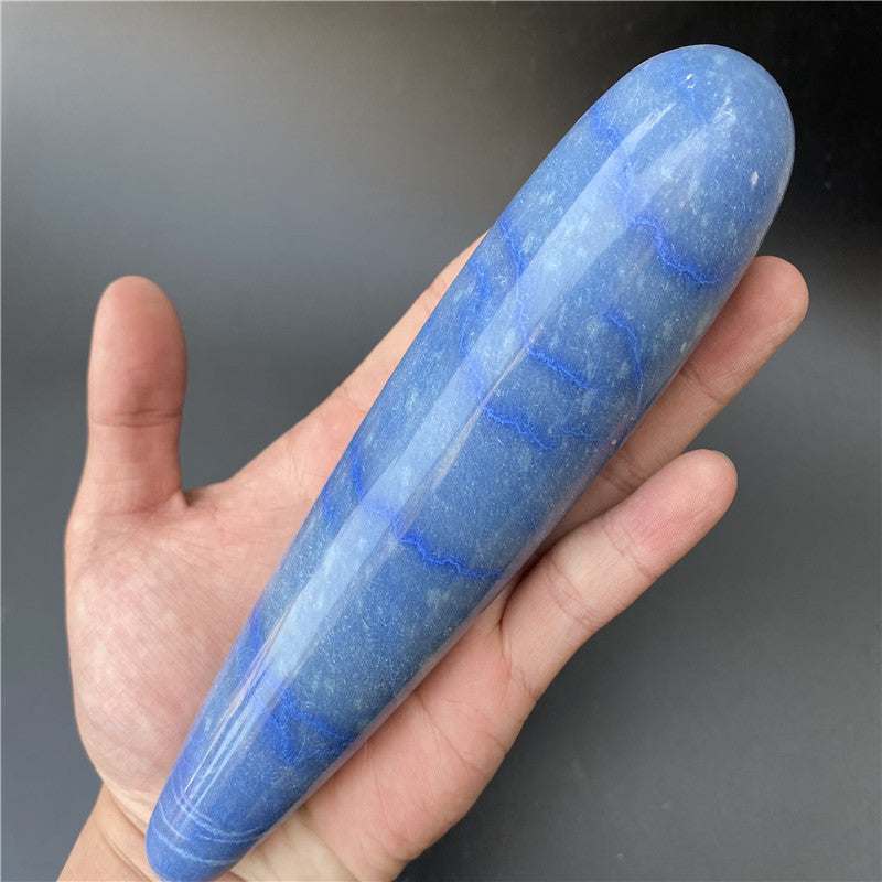Polished blue natural stone massage stick held in hand for therapy and relaxation