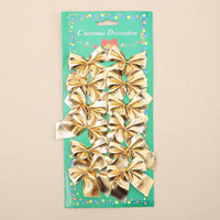 Gold Christmas tree ornament bows on green card packaging