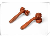 Hand holding rosewood two-wheel massager with rolling wheels for massage